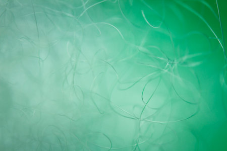 Extreme macro of polyester stable fiber on green background. Selective focus, shallow depth of...