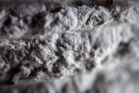 Extreme close up of old gray handmade paper clay with a structure and rough texture. Paper recycling. Selective soft focus, shallow depth of field.の写真素材