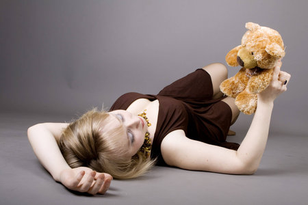 Beautiful young blond girl holding teddy bearの写真素材