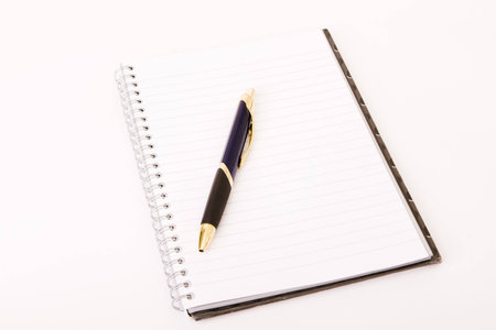 Spiral bound notebook with pen on table top