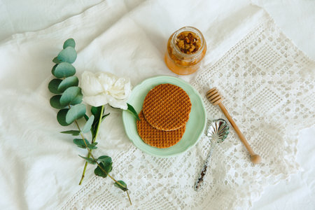Waffles with honey, eucalyptus and green leaves on a white background.の写真素材