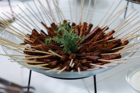 Grilled meat skewers with herbs on a metal plate. Restaurantの写真素材