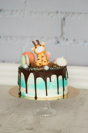 Easter cake  with macaroons, meringue and a giraffe on top.の写真素材