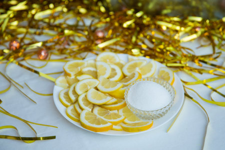 Lemon slices on a white plate with gold tinsel on the backgroundの写真素材