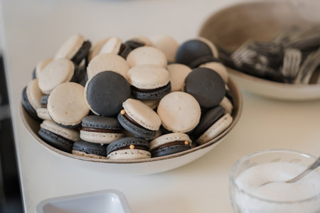 Black and white macaroon cookies on a white table. Selective focus.の写真素材