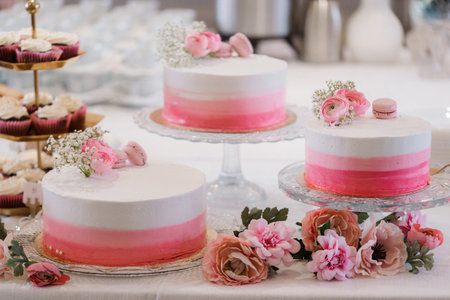 Wedding cake with pink and white flowers on the table.の写真素材