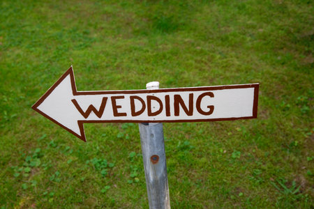 Wooden signpost with directional arrow pointing to WEDDINGの写真素材
