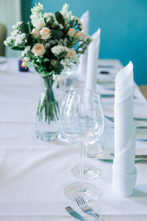 Table set for an event party or wedding reception. Glasses and cutlery on the table.