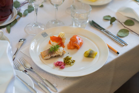 A plate of salmon and caviar on a table in a restaurantの写真素材