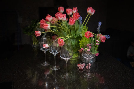 Decoration with tulips and vine glasses on the table, selective focusの写真素材