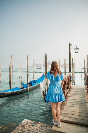 Beautiful young girl in a blue dress on the background of Veniceの写真素材