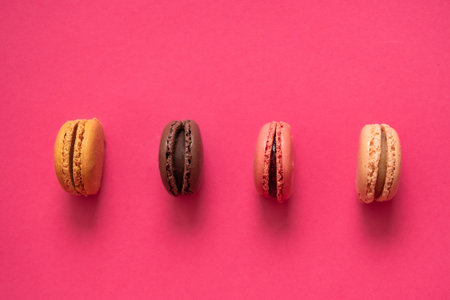 Tasty macaroons on pink background. View from above.の写真素材