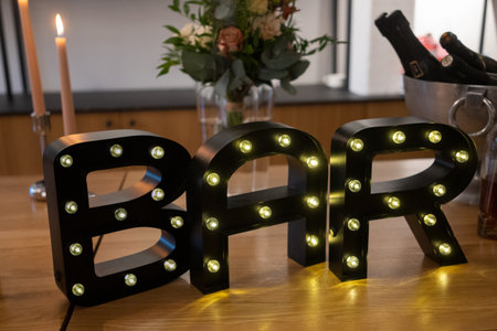Black letters B, A and R with LED lights on the wooden table. BAR led lights letters.の写真素材