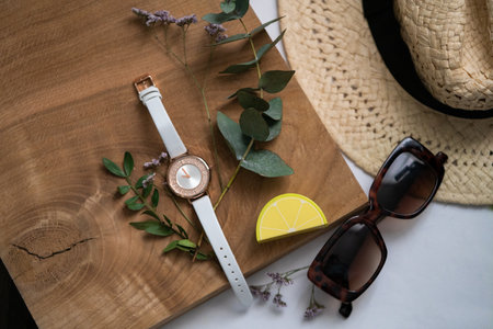 Flat lay, top view, summer concept. Wrist watch, sunglasses, lemon on wooden background.