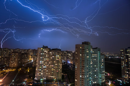 A lot of large lightning bolts in the sky above the city - over 20 lightnings