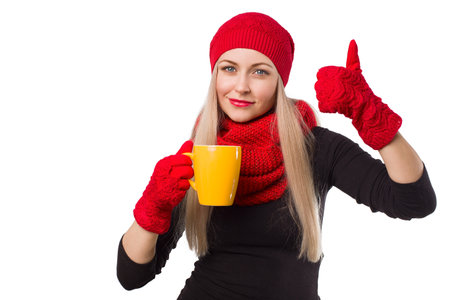 Woman in knitted red hat with cup of hot drink and thumb up symbol- isolated on white backgroundの写真素材
