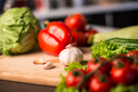 Garlic and fresh salad vegetables on the table - close up photo with composition with shallow dept of fieldの写真素材