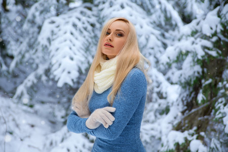 Winter portrait of smiling beautiful blonde girl in the forest under the snow - closeup beauty photo.の写真素材