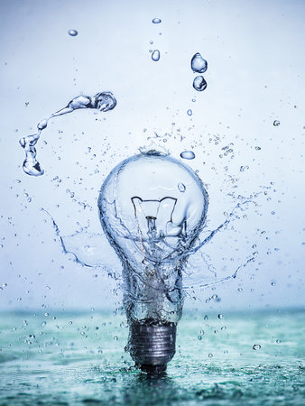 Bulb lamp with motion freezed water splashes. Conceptual ecological and nature photo.の写真素材