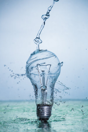 Bulb lamp with motion freezed water splashes. Conceptual ecological and nature photo.の写真素材