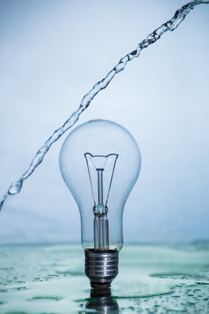 Bulb lamp with motion freezed water splashes. Conceptual ecological and nature photo.の写真素材