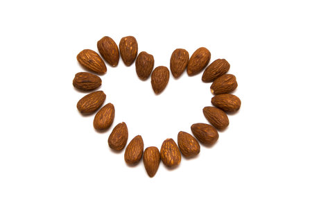 Almonds nuts heart isolated on a white backgroundの写真素材