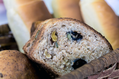 Slice of hole grain bread with nuts, olives, seeds and bran. Shallow depth of field