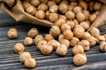 Raw chickpeas in paper bag on wooden background. Healthy foodの写真素材