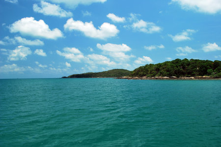 A vast sea with a mountain backdrop on a white cloud.の写真素材