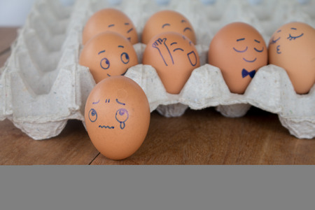 Sadness on wedding Eggs face action on egg-shell in brown paper box.の写真素材