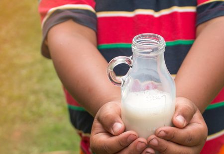 hand holding milk bottle.の写真素材
