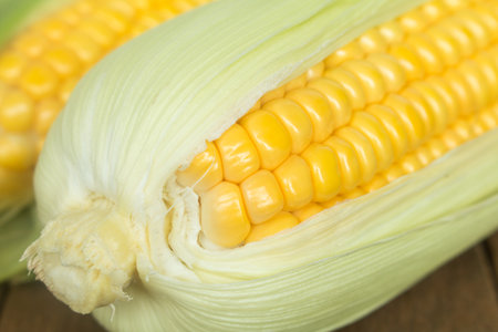Close up fresh corns on wooden table.