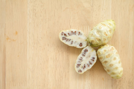 Noni or Morinda citrifolia, great morinda, Indian mulberry, beach mulberry, or cheese fruit on wood table.の写真素材