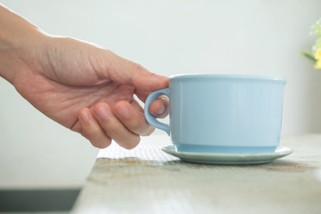 Close up of hand holding A cup of coffee