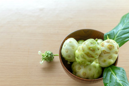 Noni or Morinda citrifolia, great morinda, Indian mulberry, beach mulberry, or cheese fruit on wood table.の写真素材