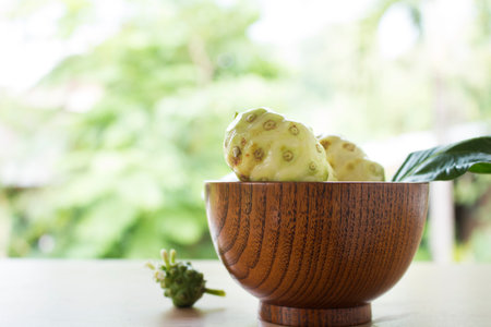 Noni or Morinda citrifolia, great morinda, Indian mulberry, beach mulberry, or cheese fruit on wood table.の写真素材
