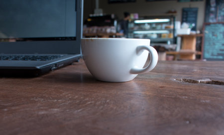 Close up of Cup of hot latte art coffee with laptop computer on wooden table, work with coffee concept picture foe business background.の写真素材
