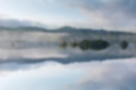 Outdoor blurred abstract background, beautifull lake with reflection on water.の写真素材