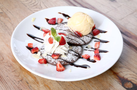 Closeup of Vanilla ice cream with pancake and Strawberry on wooden table.の写真素材