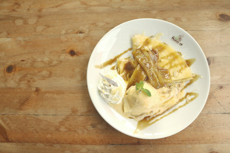 Vanilla ice cream Crepes stuffed with bananas topped and caramel whipped cream.の写真素材