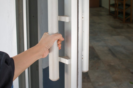 Close-up of hand open Aluminum glass door or Hand holding handle.の写真素材