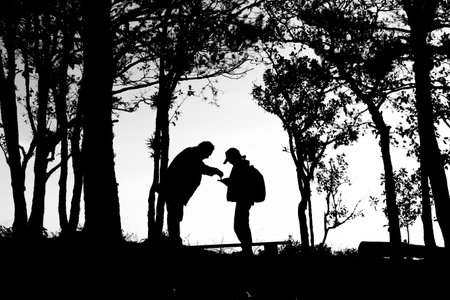 silhouette of love couple in trees border, back and white tone.