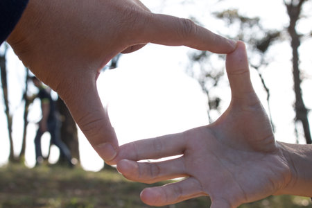 Hands make frame shape see Silhouette beautiful sunset background.の写真素材