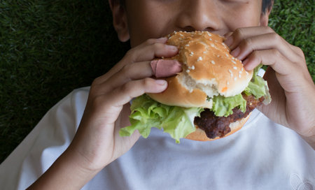 The boy's Hand holding a hamburger.の写真素材