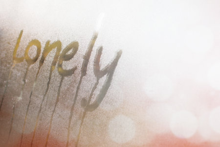 Closeup of  "Lonely" word on glass window with waterdrop concept design for valentine's day or wedding background.の写真素材