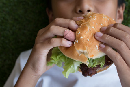 The boy's Hand holding a hamburger.の写真素材