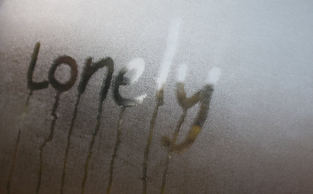 Closeup of  "Lonely" word on glass window with waterdrop concept design for valentine's day or wedding background.の写真素材