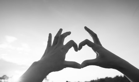 Hands in heart form love, silhouette hand make heart form with sun set.の写真素材