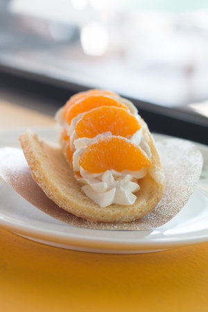 Orange topped on pancakes in coffee shop.