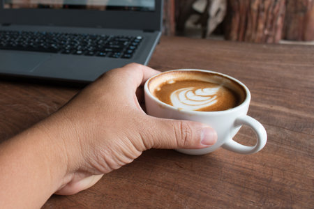Close up of Cup of hot latte art coffee on wooden table.の写真素材